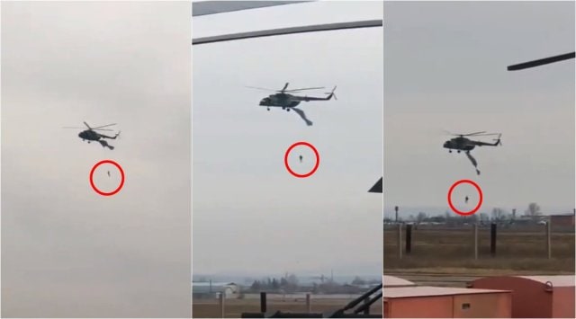 russian soldier hanging from helicopter, parachutist dangling from helicopter, russia parachute caught on helicopter, viral videos, odd news, indian express