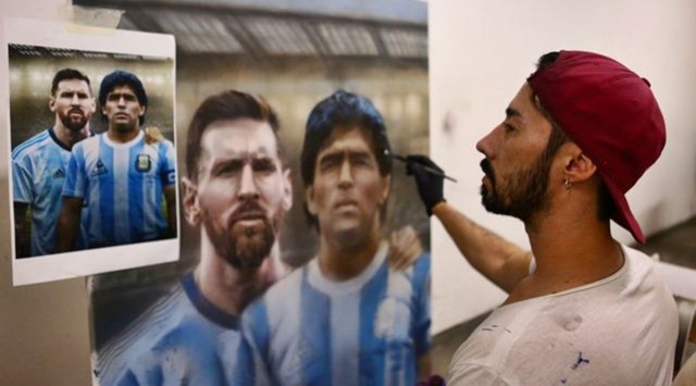 Argentine artist Maximiliano Bagnasco finishes a painting of soccer legend Diego Armando Maradona, and Barcelona's footballer Lionel Messi, at his workshop, in Buenos Aires, Argentina. (Photo: Reuters)