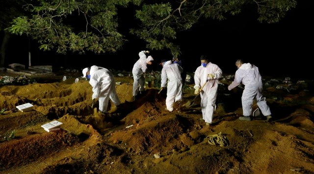 Cemetery workers bury a person who died from complications related to Covid-19, at the Vila Formosa cemetery in Sao Paulo on Wednesday. (AP)