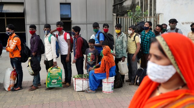 People wearing masks as a precaution against the coronavirus stand in a queue to board trains at Lokmanya Tilak Terminus in Mumbai. (AP)


