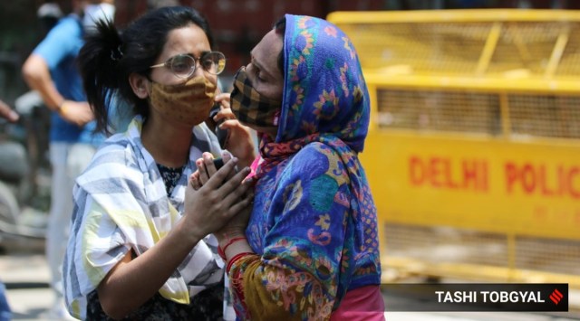 Family members of Covid-19 patients outside LNJP hospital in New Delhi on Sunday. (Express Photo by Tashi Tobgyal)