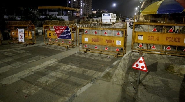 Policemen put up barricades near the Delhi-Uttar Pradesh border to impose the weekend curfew. (Express Photo: Praveen Khanna) 