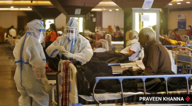 Health workers in PPE suits treat Covid-19 patients at a Isolation center in New Delhi on Saturday. EXPRESS PHOTO BY PRAVEEN KHANNA 17 04 2021.