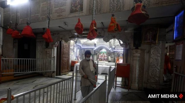 A priest sanitises a temple in New Delhi. (Express photo/Amit Mehra)