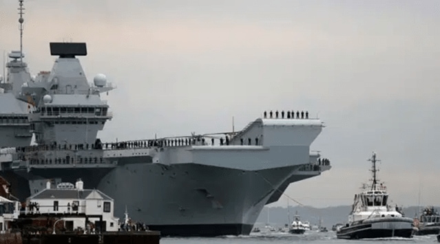 The Royal Navy's new aircraft carrier, HMS Queen Elizabeth, is towed by tugs as it arrives at Portsmouth Naval base, its new home port, in Portsmouth, Britain August 16, 2017.   (REUTERS/Peter Nicholls)
