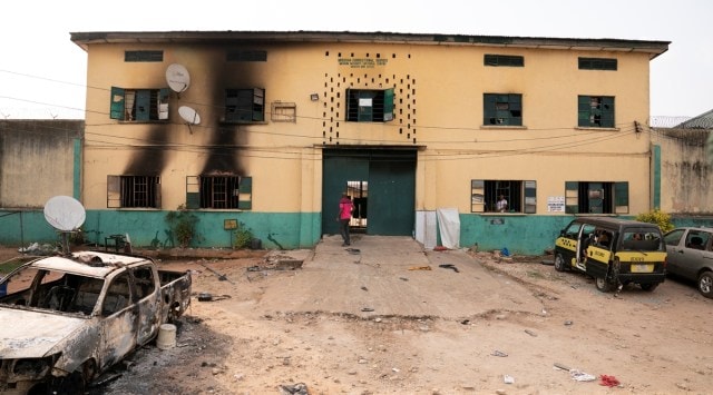 A man is seen standing in front of the main gate of the Nigerian Correctional Services facility that was attacked by gunmen, with large numbers of inmates set freed afterwards in Imo State, Nigeria April 5, 2021. (Reuters)