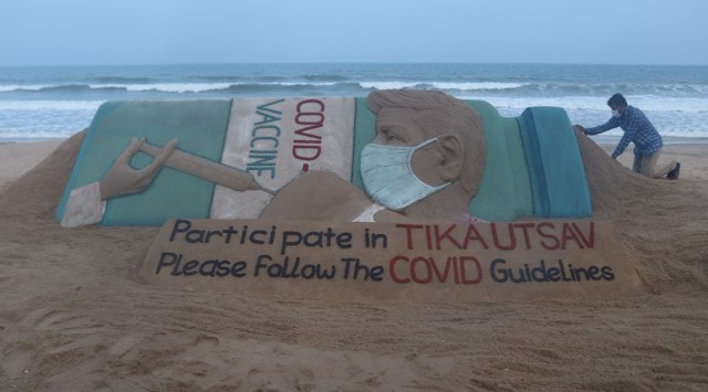 Sand artist Sudarshan Pattnaik makes a sand sculpture to create awareness on Covid-19 vaccination, in Puri on Saturday. (PTI)