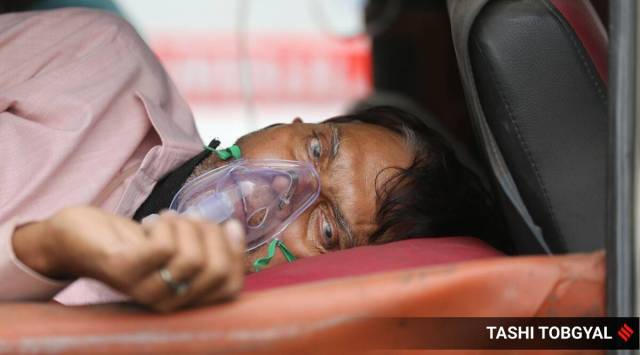 A patient waits outside a hospital in New Delhi. (Express Photo: Tashi Tobgyal)