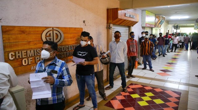 People queue up outside the Chemists Association of Pune to buy Remdesivir injections. (Express Photo: Ashish Kale)