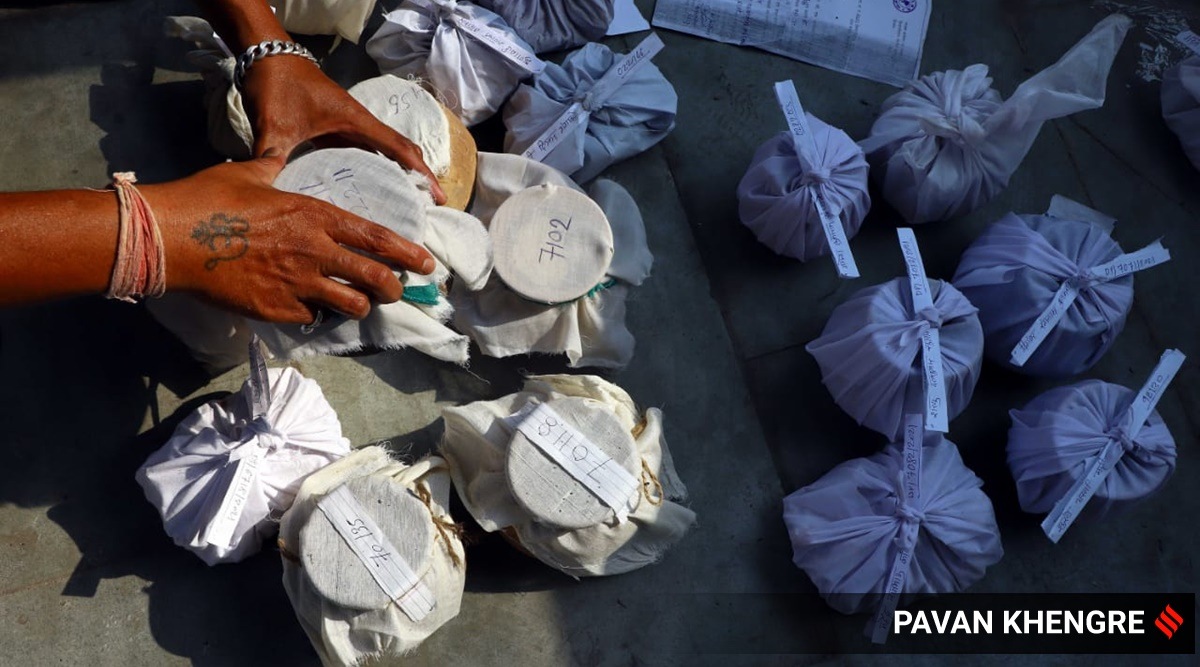 A worker at Pune's Kailas Crematorium near Sangamvadi segregates the Asthi (cremated remains) of the persons who died of COVID-19 (Express photo/Pavan Khengre)