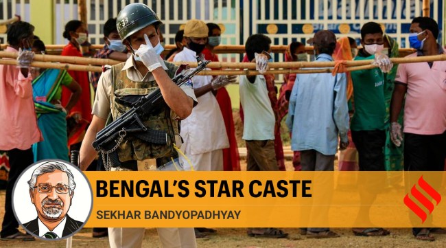 A BSF soldier stands guard as voters stand in queue to cast their votes at a polling booth during first phase elections in West Bengal (AP)