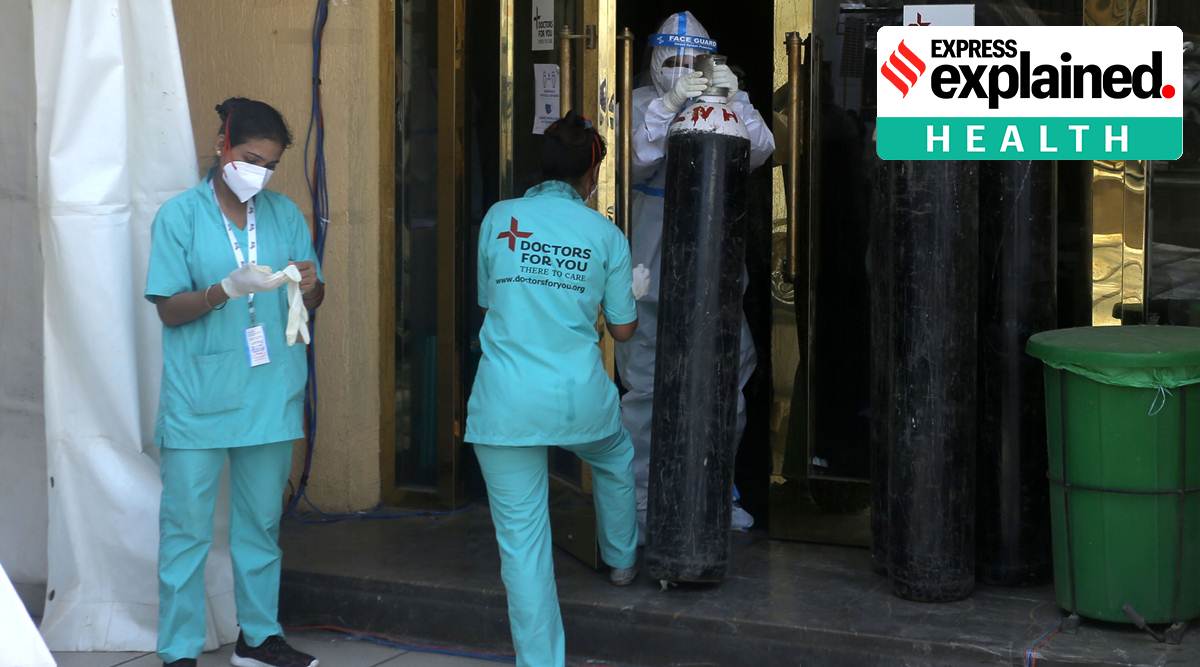 Healthcare workers prepare beds at Shehnai Banquet Hall in New Delhi, which has been converted into a temporary ward for Covid-9 patients. (Express Photo: Amit Mehra)