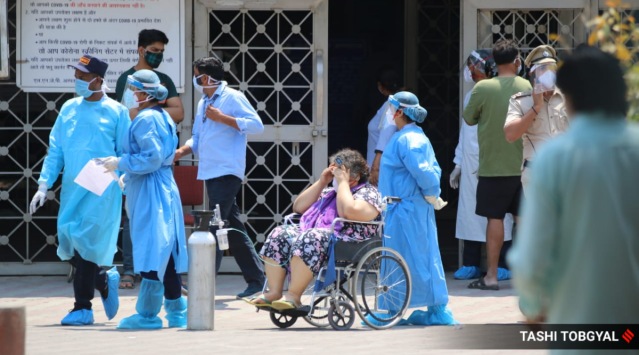 Patients with Oxygen cylinders wait to get admission into the LNJP hospital in New Delhi on Thursday.