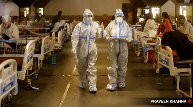 Health workers in PPE suits treat Covid-19 patients at an isolation center in New Delhi on Saturday. 