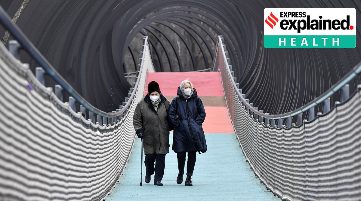 People wear protective face masks due to the coronavirus pandemic, as they walk over a bridge during the lockdown in Oberhausen, Germany. (AP Photo/Martin Meissner, file)