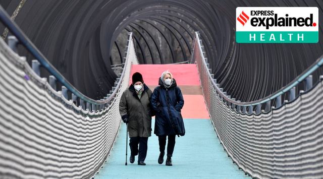 People wear protective face masks due to the coronavirus pandemic, as they walk over a bridge during the lockdown in Oberhausen, Germany. (AP Photo/Martin Meissner, file)