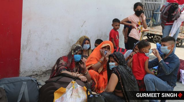 Migrants waits to board a train at the Ludhiana railway station amid the second wave of Covid-19 infections. (Express Photo: Gurmeet Singh)