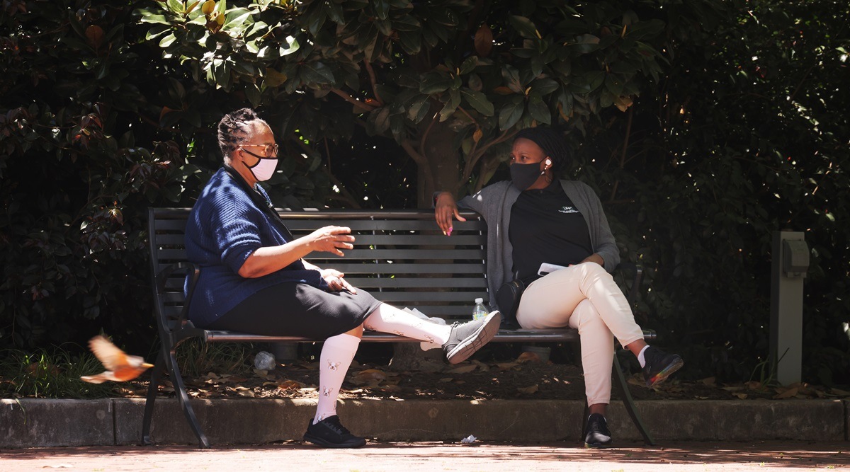 People wear face masks at a park in Charlotte, N.C. on Tuesday, April 27, 2021. (Travis Dove/The New York Times)