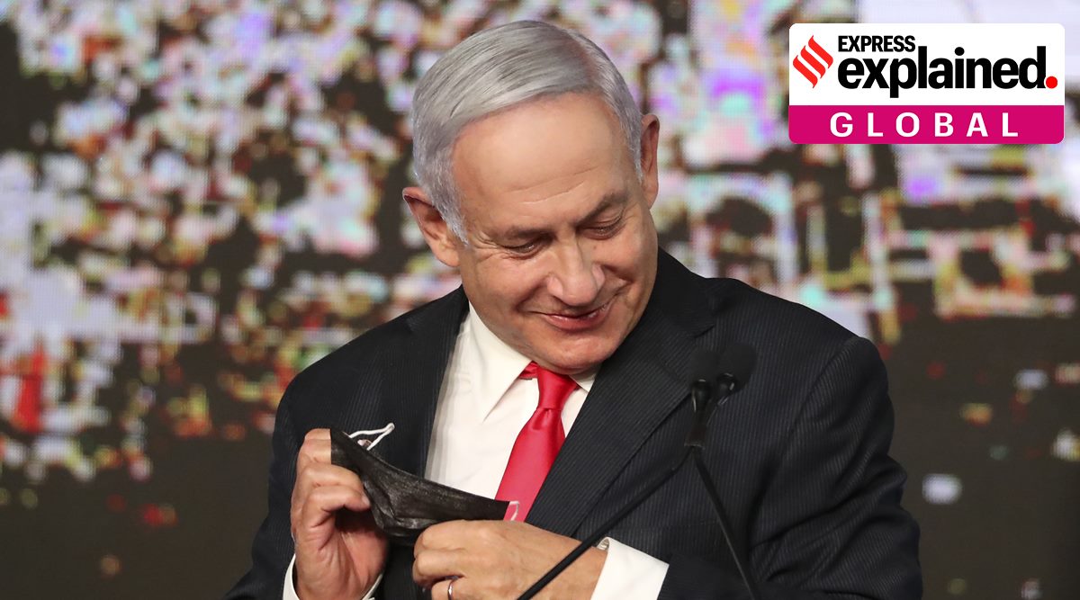 Israeli Prime Minister Benjamin Netanyahu takes off his face mask as he addresses his supporters after the first exit poll results for the Israeli parliamentary elections at his Likud party's headquarters in Jerusalem, Wednesday, March 24, 2021. (AP Photo/Ariel Schalit)