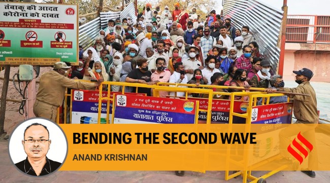 Devotees stand behind barricades as they wait for Naga Sadhu to arrive for Shahi snan during Kumbh mela, in Haridwar (AP)