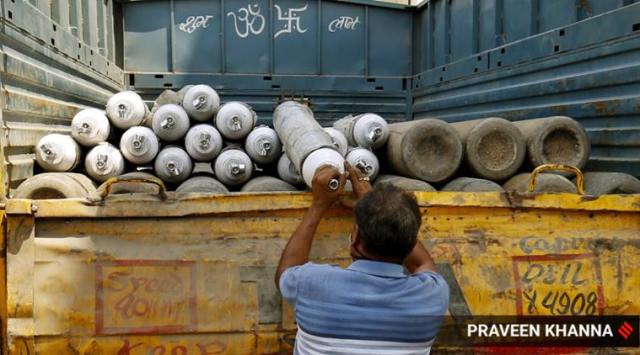 A man loading oxygen cylinders in a truck for supply. (Express photo by Praveen Khanna)