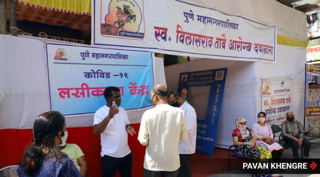 Citizens wait outside a vaccination centre at the Tambe PMC Dispensary in Dhankawadi Monday. Express Photo By Pavan Khengre
