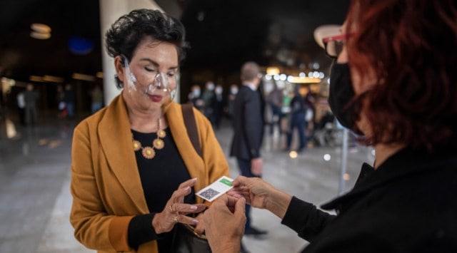 A woman shows her Green Pass before entering a show at an opera house in Tel Aviv, Israel, March 19, 2021. (Dan Balilty/The New York Times)