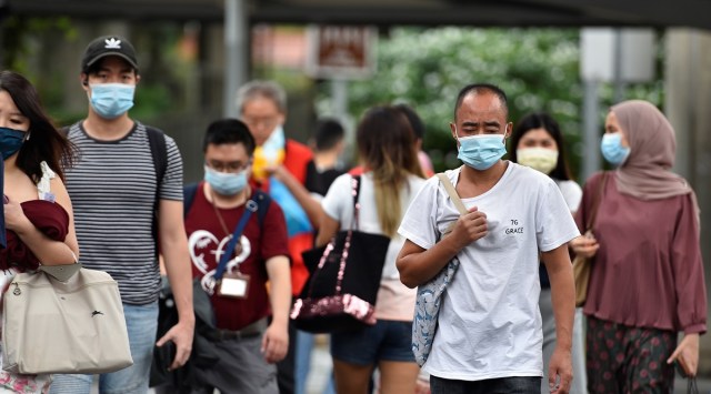 People wearing face masks cross a road amid the coronavirus disease (COVID-19) outbreak in Singapore May 14, 2021. (Reuters)