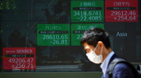 In this May 10, 2021, file photo, a man wearing a protective mask rides a bicycle in front of an electronic stock board showing Japan's Nikkei 225 and other Asian indexes at a securities firm, in Tokyo. Asian shares were mixed Monday, May 24, echoing Wall Street's mixed close last week. (AP)