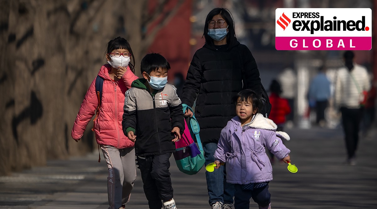 Children wearing face masks run along a path at a public park in Beijing. (AP Photo/Mark Schiefelbein)