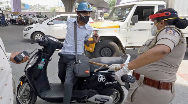 A policewoman catches hold of a motorist violating lockdown norms in Bengaluru on Sunday. (PTI)