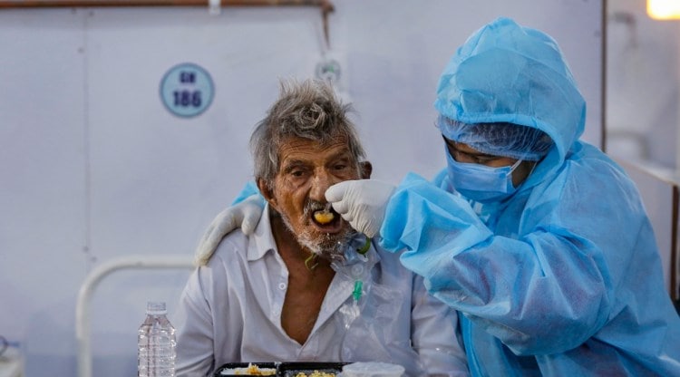 A health worker feeds a Covid-19 patient inside Dhanvantri Covid-19 hospital, in Ahmedabad, Thursday, May 27, 2021. (PTI)