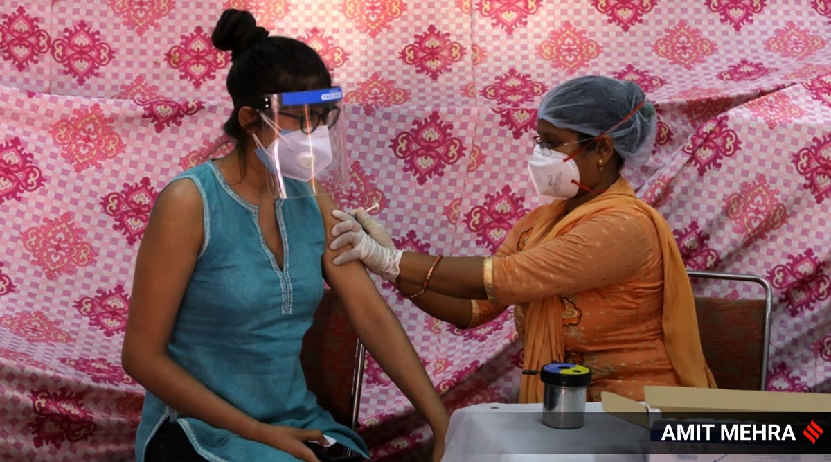 A young woman receives her first dose of a Covid-19 vaccine in New Delhi. (Express Photo: Amit Mehra)