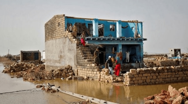 People are seen in a damaged house following Cyclone Tauktae in Vadhera village in the western state of Gujarat, India, May 19, 2021. (REUTERS/Amit Dave)