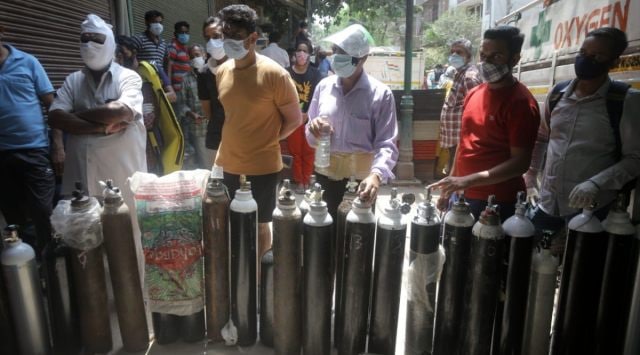 Family members of COVID-19 patients wait to fill their empty cylinders with medical oxygen outside an oxygen filling centre, at Bhogal, in New Delhi.  (Express Photo By Amit Mehra)
