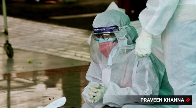 Kin of a Covid-19 victim wait at a crematorium in New Delhi. (Express Photo: Praveen Khanna)