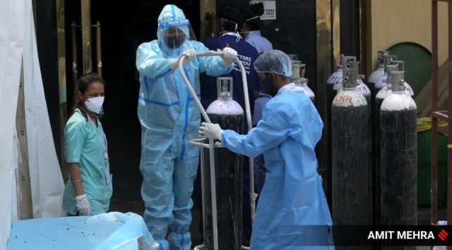 A health worker adjusts an oxygen cylinder at a Shaihnai banquet hall, converted into a COVID-19 isolation center, in New Delhi. 