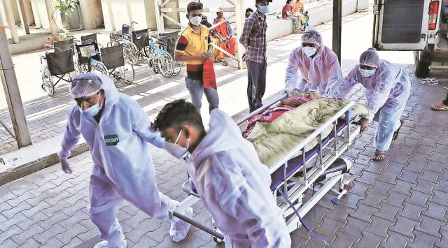 A Covid patient on oxygen support wheeled into a Covid facility in Ahmedabad on Wednesday. (Express Photo by Nirmal Harindran)