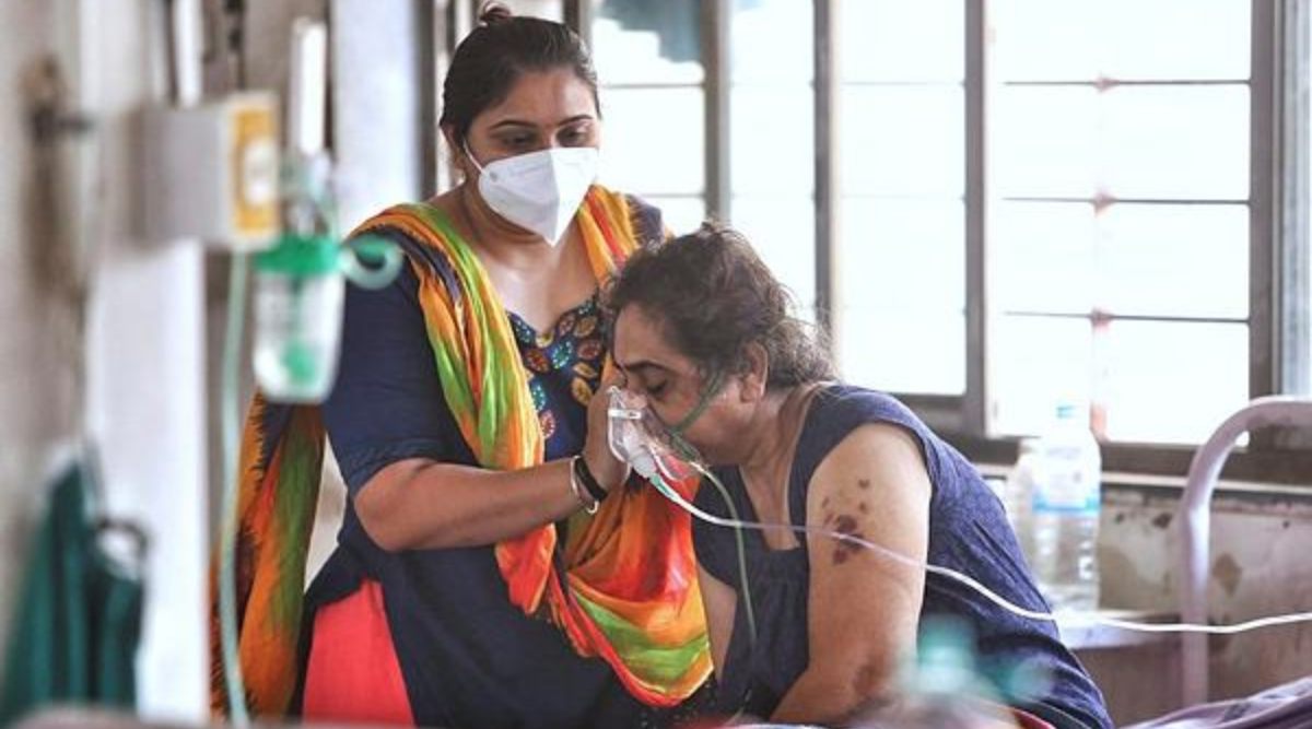 Bystander comforts an infected patient at Mucormycosis ward of Civil hospital in Ahmedabad on Friday. Gujarat has declared the black fungus as epidemic following centres order. (Express photo by Nirmal Harindran)