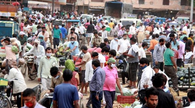 People buy vegetables at a wholesale vegetable market, during the ongoing COVID-19 lockdown, in Gurugram.  (PTI Photo/file)