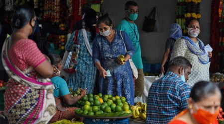 A woman wearing a protective face mask buys fruit in a market, amidst the spread of the coronavirus disease (Covid-19) in Mumbai, India. (REUTERS)