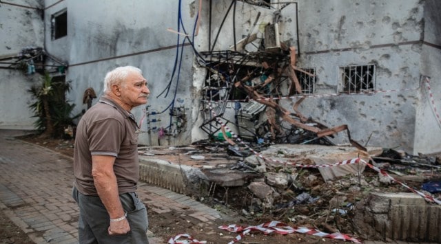 A man inspects the damage to a building on Monday, May 17, 2021, in Ashdod, Israel, caused by a rocket fired from Gaza Strip. (Dan Balilty/New York Times)