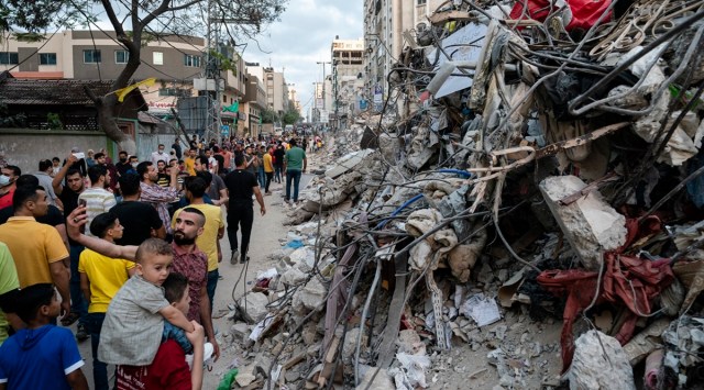 People look at the rubble from a building previously destroyed in an air-strike, in Gaza City on Friday. (AP)