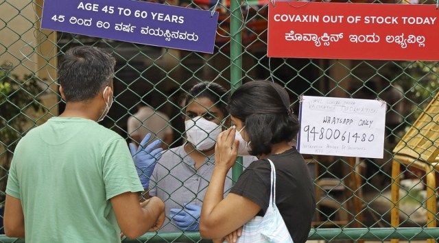 A couple waits outside a vaccination centre in Bengaluru on Saturday. (PTI)