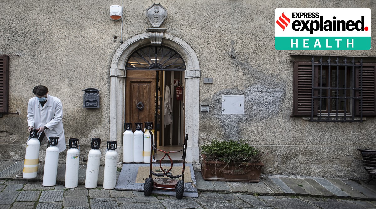 A local pharmacist, lines up empty oxygen canisters in the back of a pharmacy to be replaced with full ones, in the Tuscan village of Castellina in Chianti, in Italy on Dec. 17, 2020. Delivering oxygen through cans costs 10 times as much as delivering it in bulk. (Nadia Shira Cohen/The New York Times)
