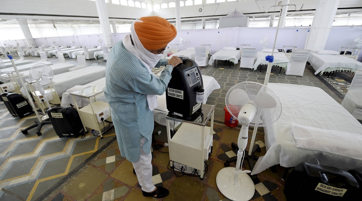 A volunteer shows an oxygen concentrator machine at the Guru Tegh Bahadur Covid Care Centre at the Gurdwara Rakab Ganj Sahib in New Delhi. (PTI)
