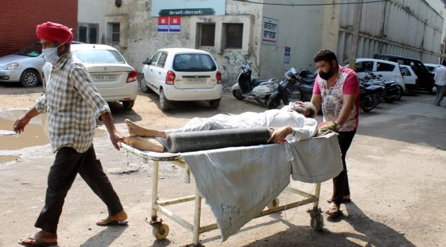 Family members carry Covid infected patient  to be  admitted  at Government Rajindra Hospital in Patiala. (Express Photo by Harmeet Sodhi)