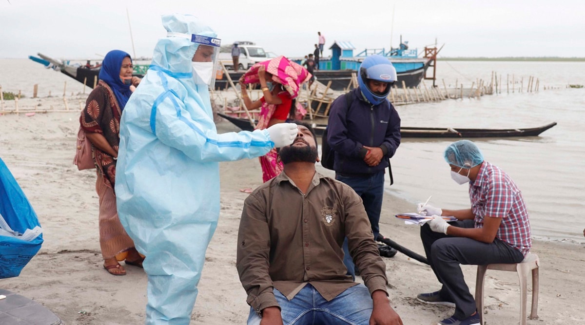 A healthcare worker collects swab sample of a person in Majuli, Assam, on Saturday. (PTI)