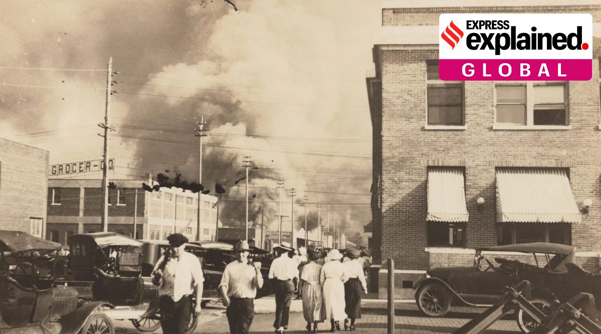 Two armed men walk away from burning buildings as others walk in the opposite direction during the June 1, 1921, Tulsa Race Massacre in Tulsa, Okla. (Department of Special Collections, McFarlin Library, The University of Tulsa via AP)