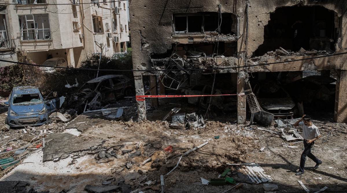 A person walks among the rubble of a destroyed building in Petah Tikva, Israel on Thursday, May 13, 2021, after it was hit by a rocket fired from Gaza Strip overnight. (New York Times)
